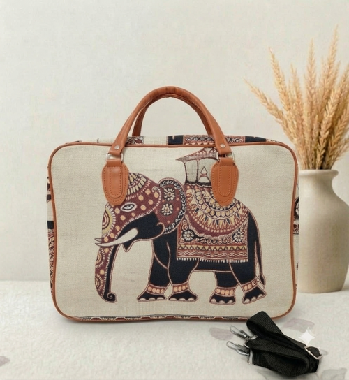 A structured canvas travel duffle bag featuring a detailed traditional Indian royal elephant motif, accented with brown top handles and complete with a detachable shoulder strap.