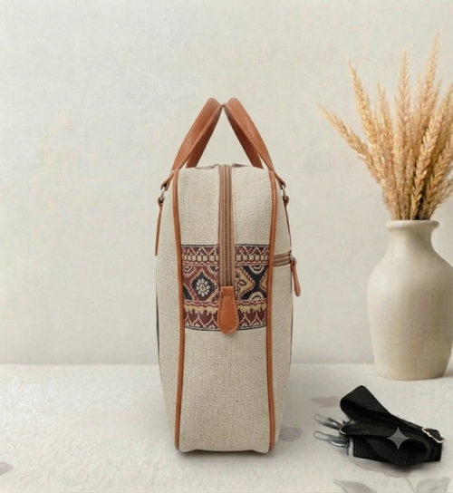 A structured canvas travel duffle bag featuring a detailed traditional Indian royal elephant motif, accented with brown top handles and complete with a detachable shoulder strap.