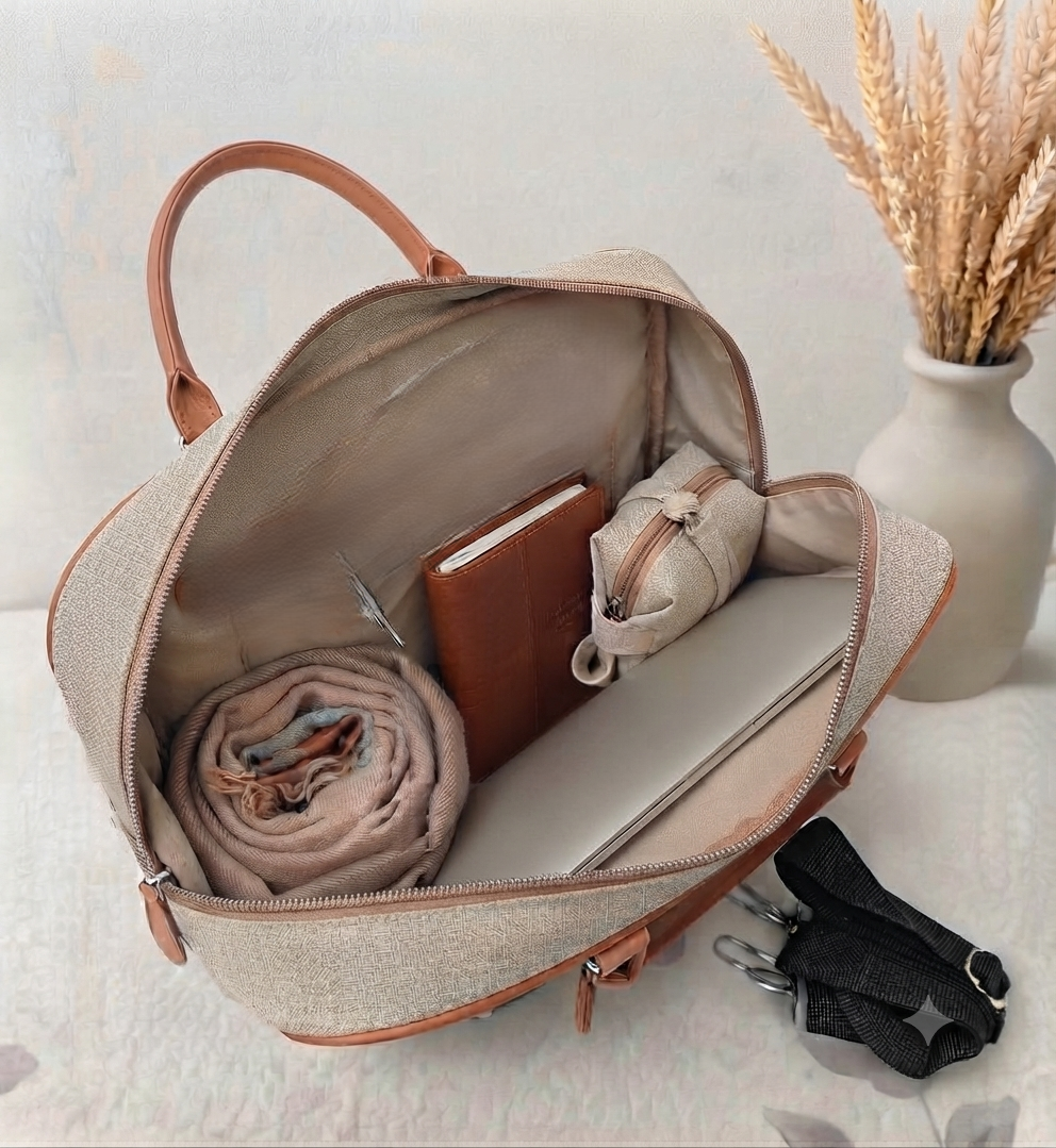 A structured canvas travel duffle bag featuring a detailed traditional Indian royal elephant motif, accented with brown top handles and complete with a detachable shoulder strap.