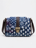 A textured crossbody sling bag featuring a vibrant multicolor front panel, shown open to display two top zipper sections and an adjustable shoulder strap.