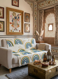 A soft cotton sofa throw blanket featuring a textured cloud and rain pattern draped over a living room couch.